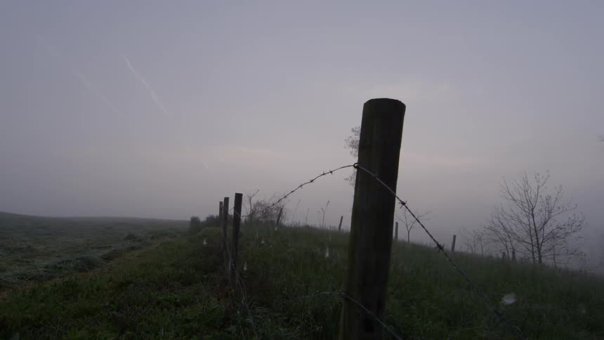 A fence lines this field at sunset