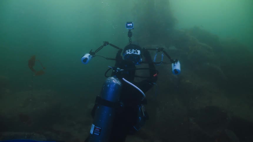 A scuba diver is taking pictures underwater