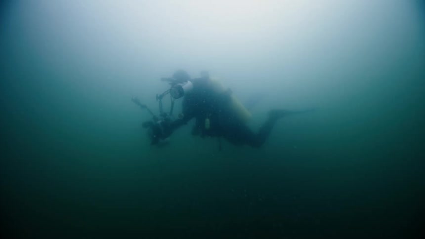 A diver filming in the ocean underwater