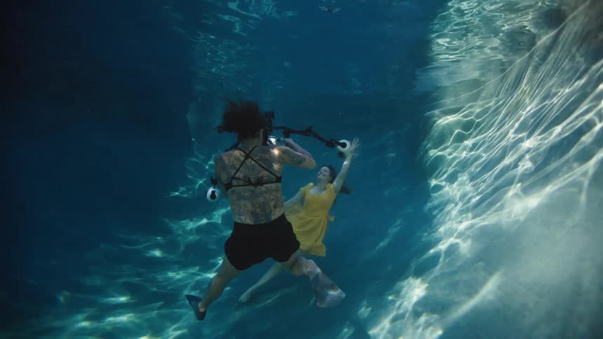 Two women taking photos underwater