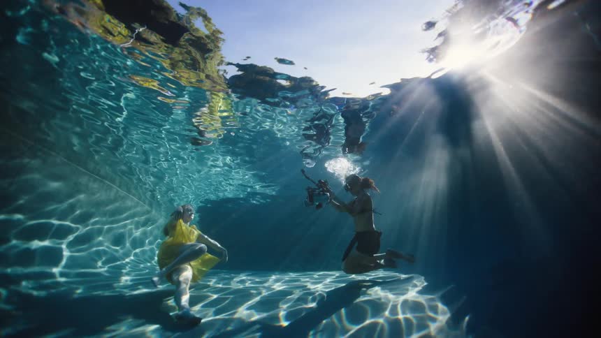 Woman takes pictures underwater in swimming pool