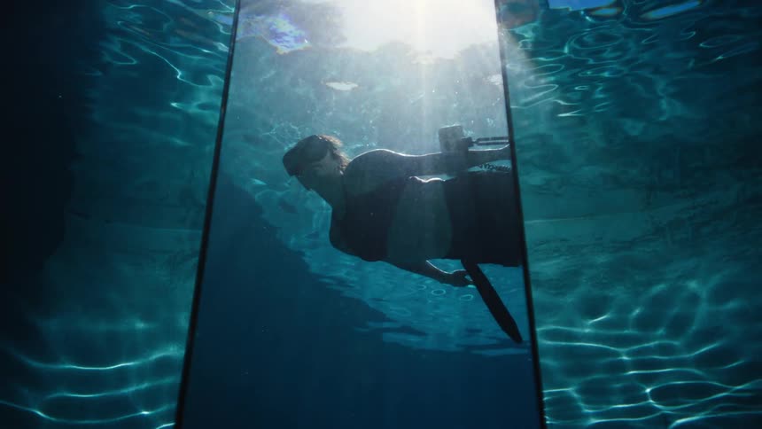View of underwater photographer reflected in a mirror in a pool