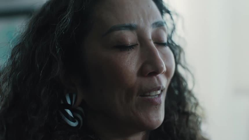 Closeup of a womans face talking with her eyes closed