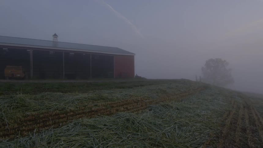 A grass hill leads to a barn