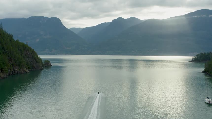 A jet ski travels down the river towards the mountains