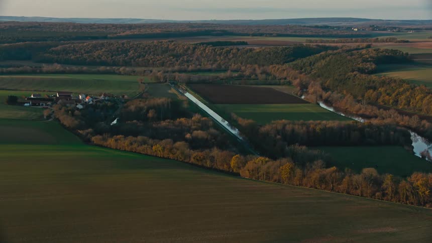 A rural region with a farm and small forests