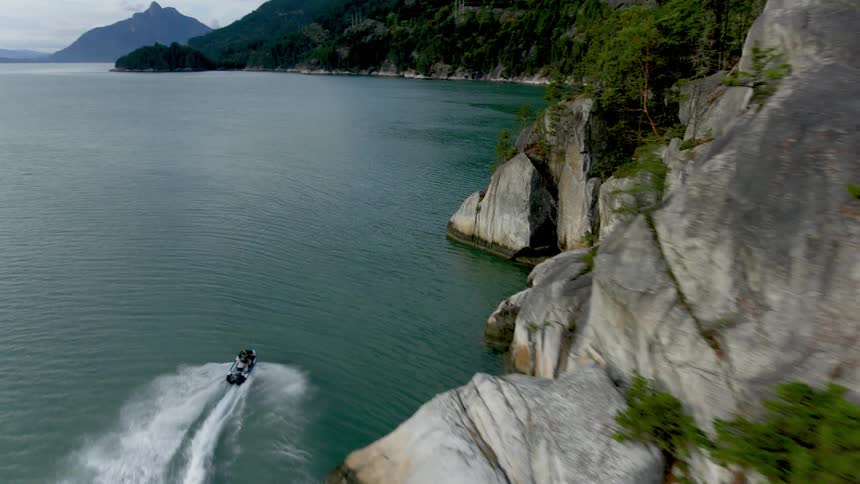 Aerial view of a person riding a jet ski on a lake in the mountains
