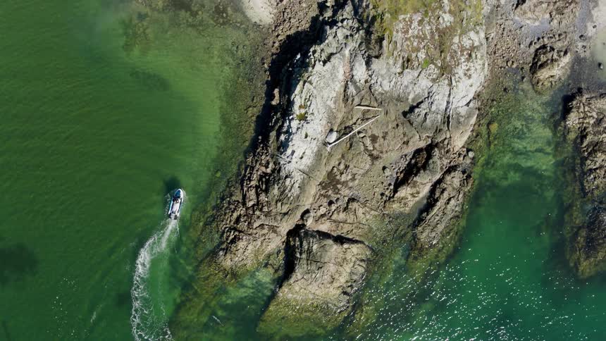 Aerial of a boat sailing near the coast