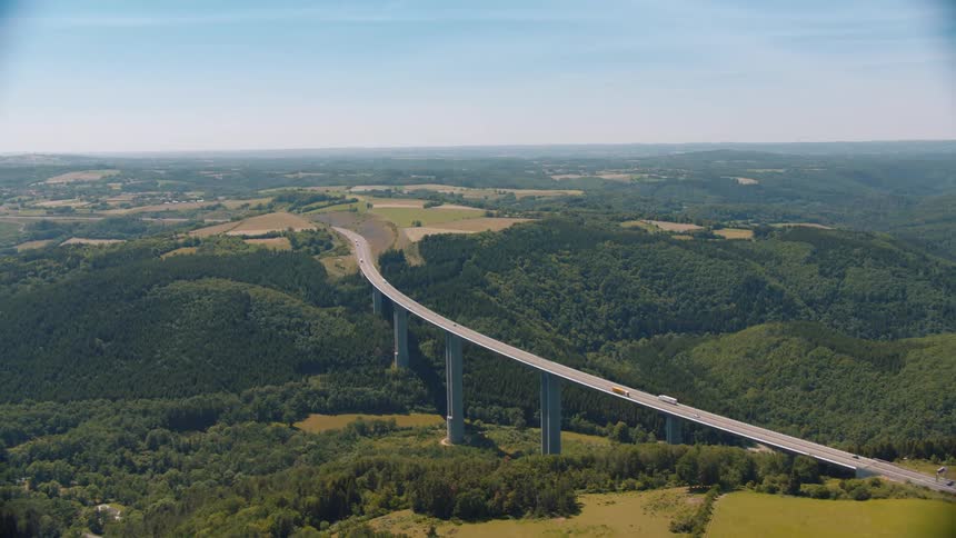 Aerial view of a viaduct with vehicles passing over it and a landscape of plains in the background