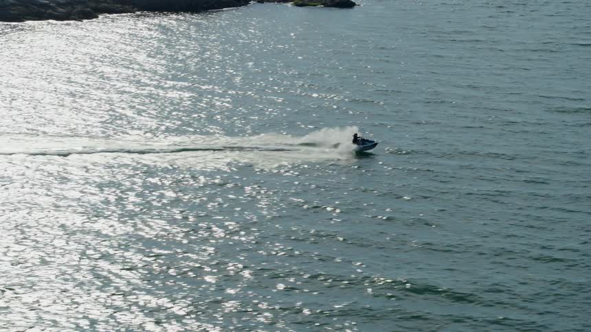 A person is speeding on their jet ski in the water