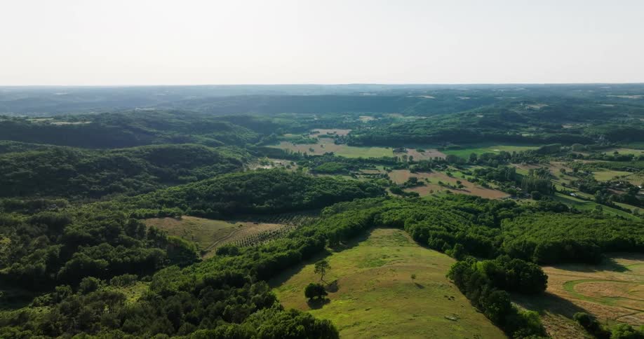 Aerial view of forested green hills and fields
