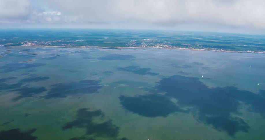 An aerial view of a coastal region facing the blue sea