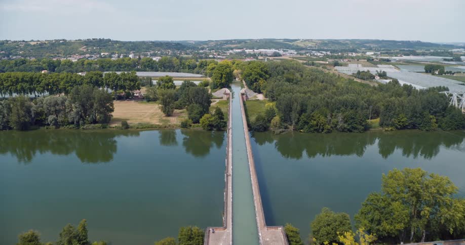 Aerial view of a lake with a central bridge a water reservoir and extensive vegetation