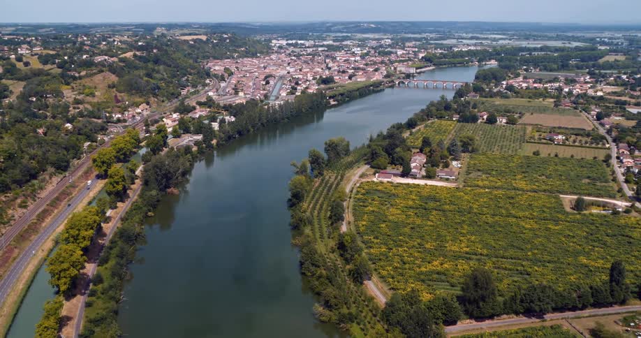 Aerial view of an urban cityscape amidst a natural environment with plains rivers and bridges