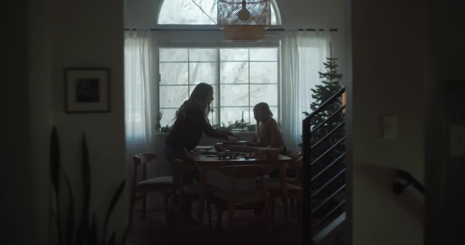 Mother and daughter wrapping gifts for christmas at home