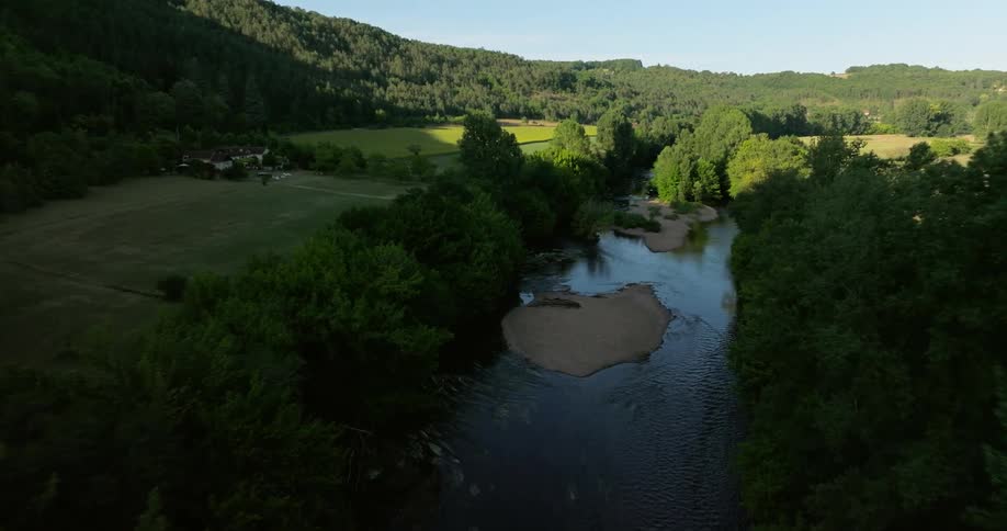 Aerial view of a landscape with a central river surrounded by nature fields and trees