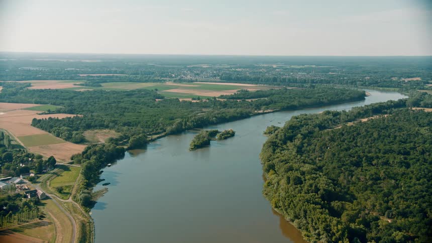 Aerial view of a river amidst plains and vegetation