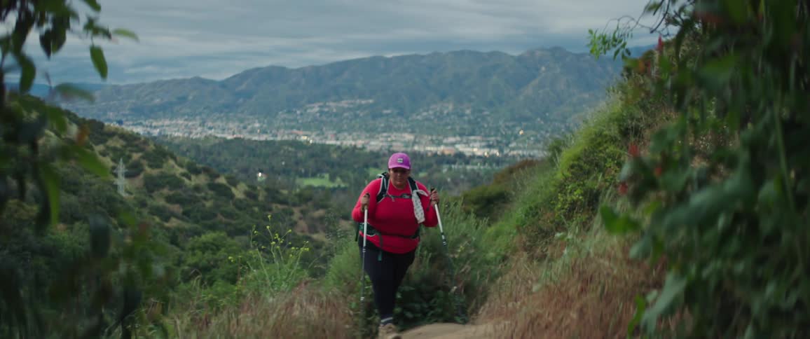 A woman is hiking up the hill
