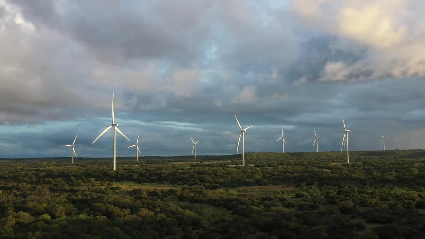 Aerial view of wind turbines spinning on a field