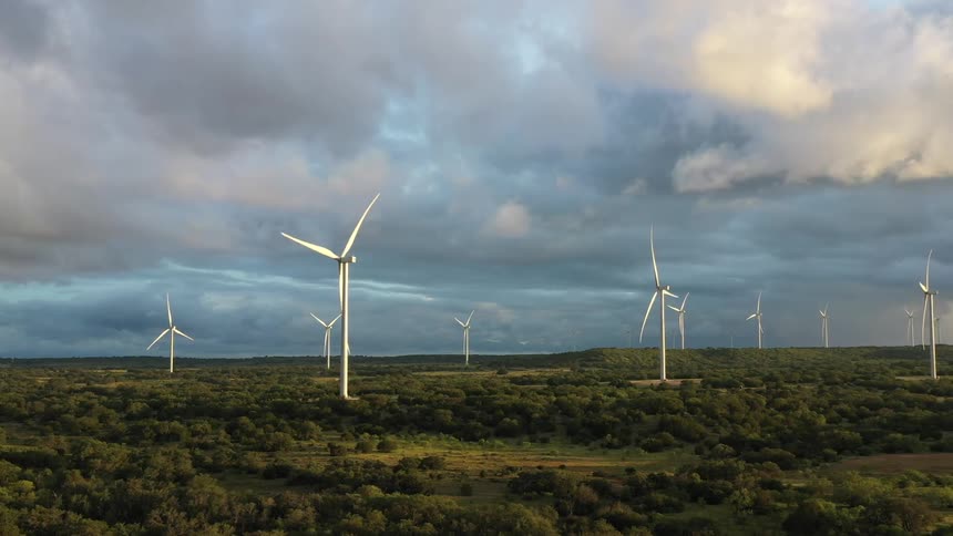 Aerial view of wind turbines spinning on a field