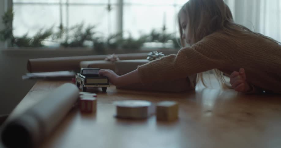 A girl is playing with her toy truck