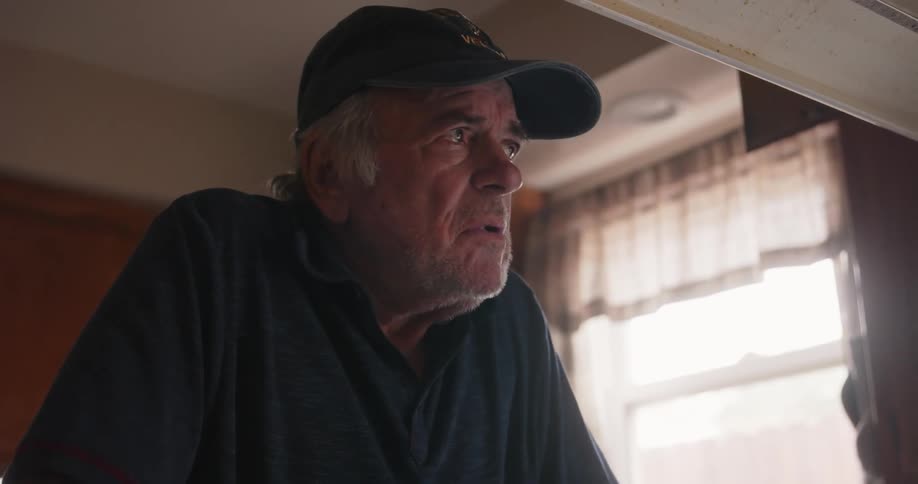 Elderly man in the kitchen deep in thoughts after stirring soup