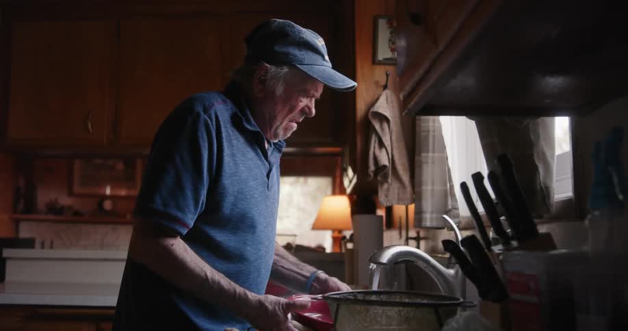 A man is cleaning dishes at home