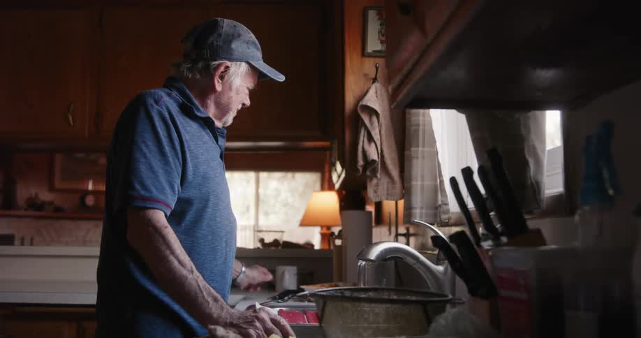 A man beings to clean the dishes