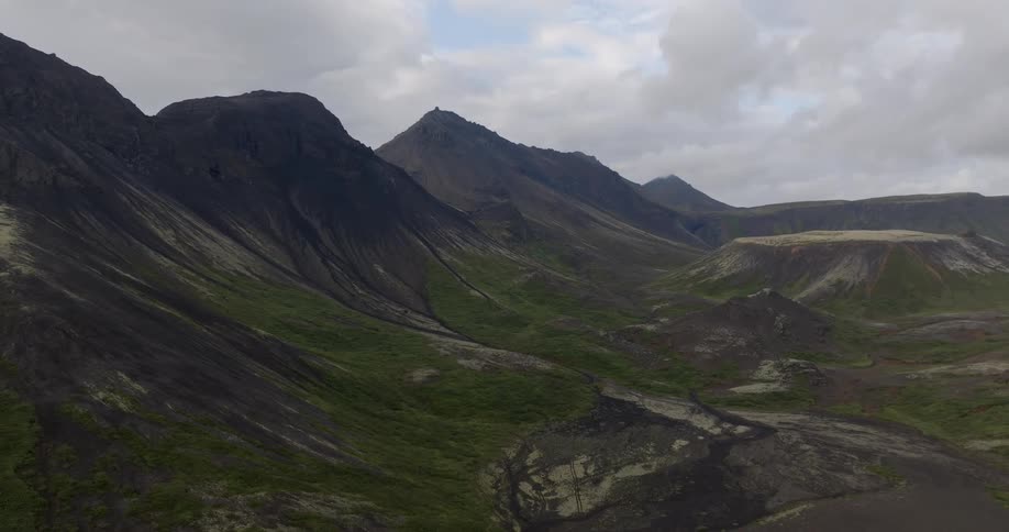 Aerial view of a natural area with a mountain range sparse vegetation on a cloudy day