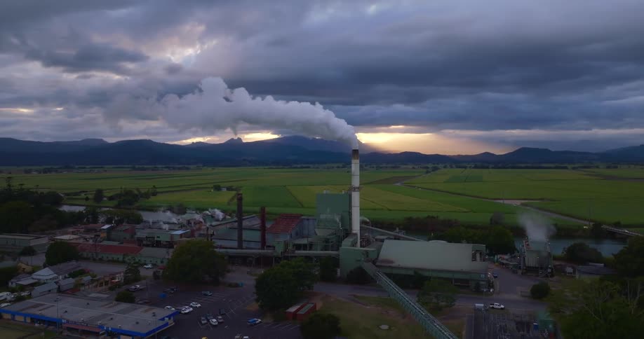 Smokes in the air from an industrial chimney at dusk
