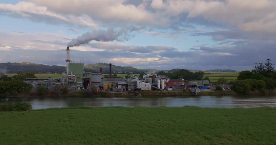 View of the exterior of a factory in operation within a natural environment by the riverside