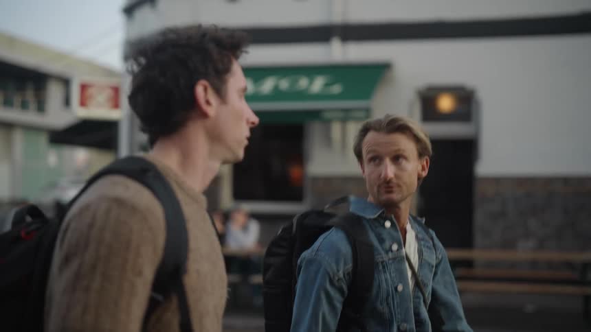 Men walking with backpacks on their backs on the streets of a neighborhood