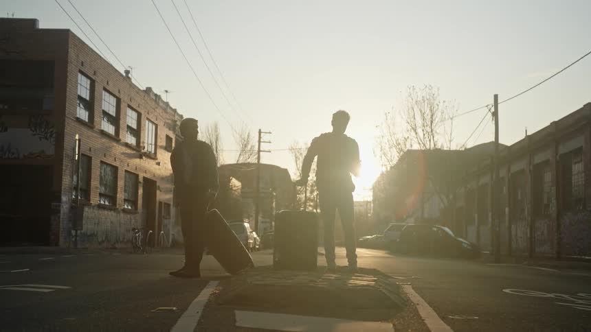 Two men crossing the street stopping in the middle and then turning back from where they came on a morning dawn