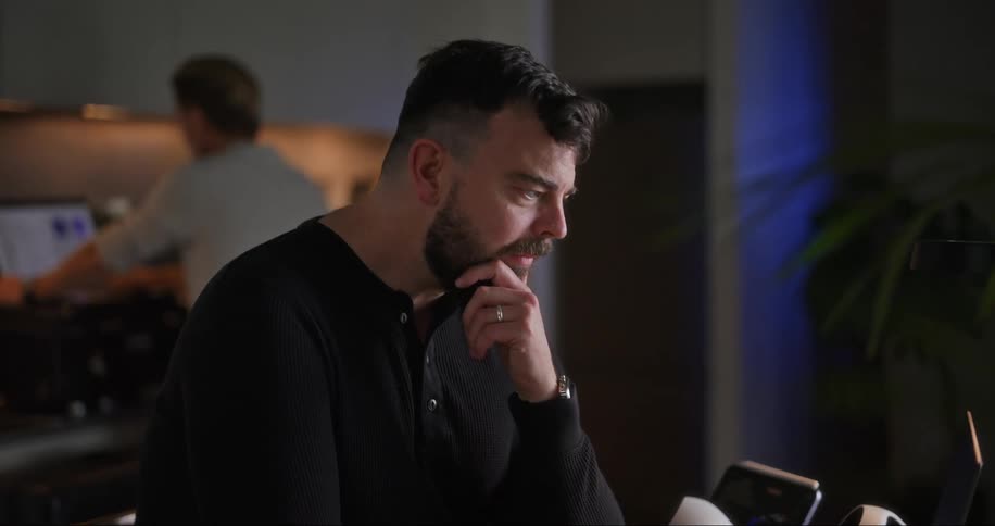 Two men are using computers in the office