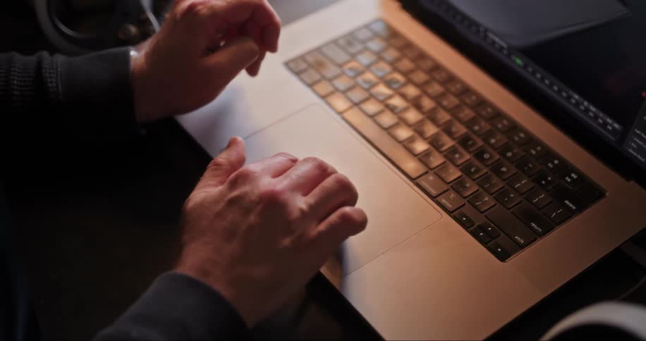 Closeup of a persons hand working on a project on their laptop