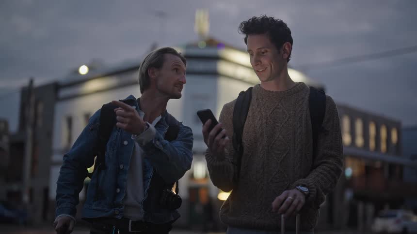 Couple of tourists try to orient on a town street at evening