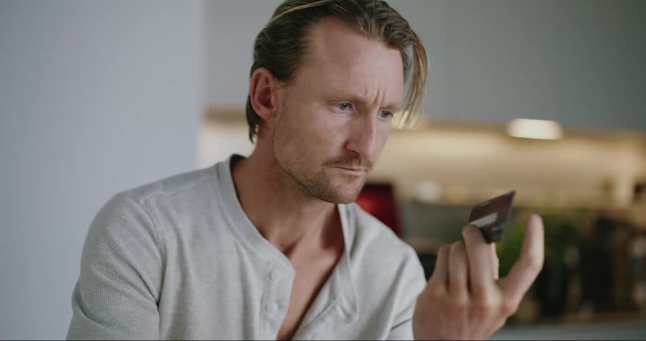 A man is examining his credit card