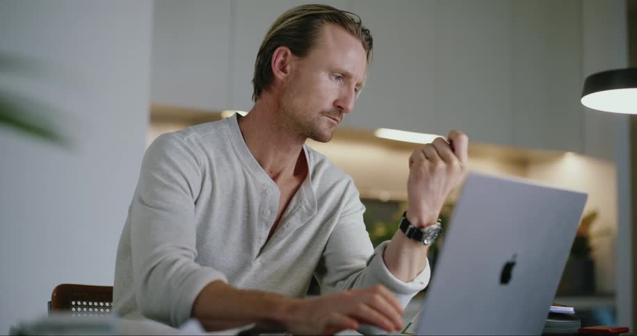 A man is entering a credit card into the laptop