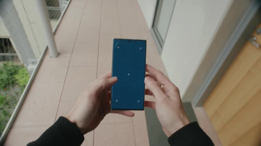 Person walk towards a door while operating an handset