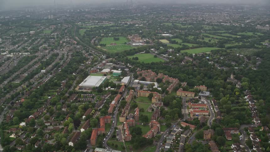 Aerial of trees and buildings in a suburban area at midday