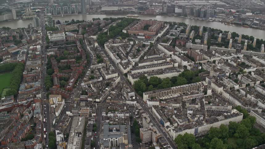 Traffic moves along a network of city streets between the river and the train tracks
