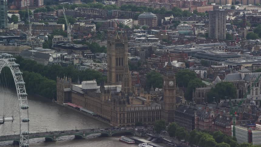 Aerial view of a city by the sea with bridges and a ferris wheel