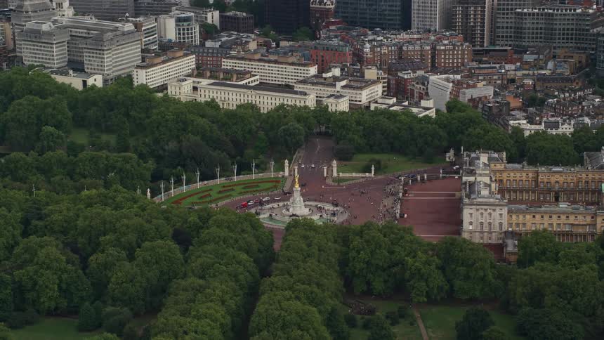Aerial view of a central monument in a forest next to a city with people visiting