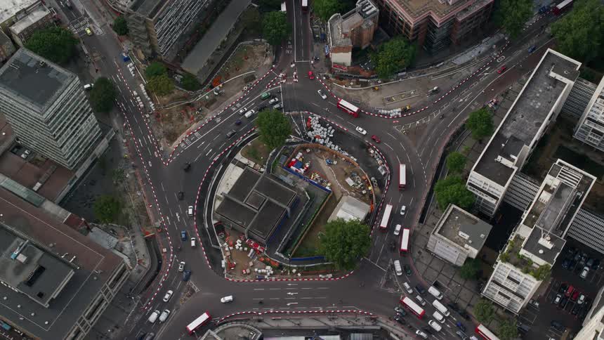 An intersection of several streets in a city that is full of cars and buses