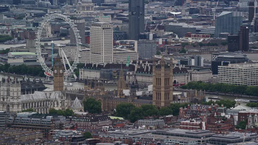 Ferris wheel towers over thames river in london near the palace of westminster