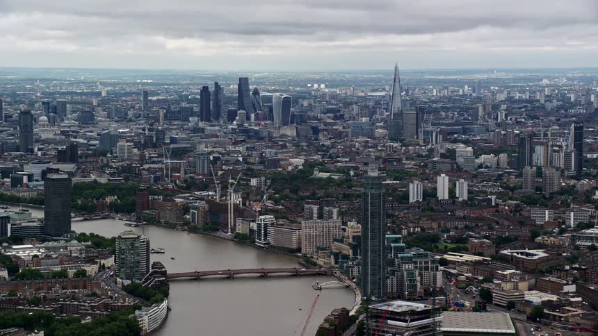 A city with tall buildings and low houses and a huge river crossing part of it
