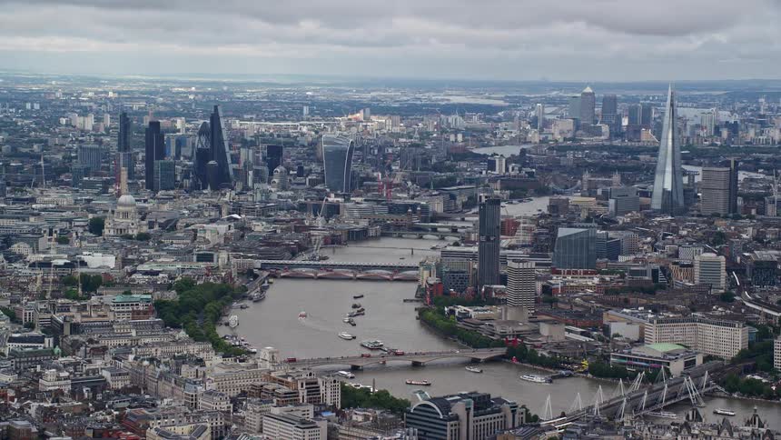 A huge city with a wide river full of boats sailing by