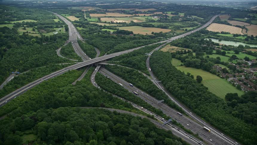 Aerial view of a highway area with overpasses moving cars and abundant vegetation in rural areas