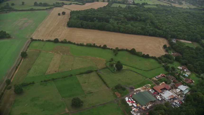 Aerial of buildings and trees in a suburban area at midday