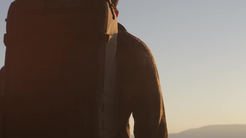 A man is overlooking a lake ahead at sunset